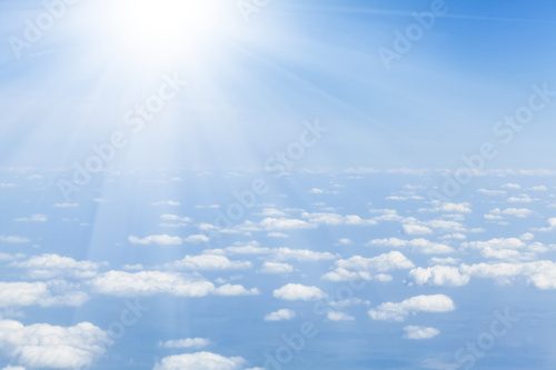 Fototapeta Niebieskie niebo z chmurami i słońcem