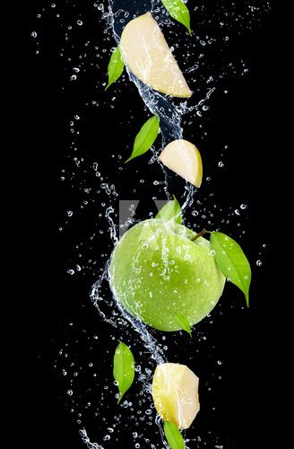 Obraz Zieleni jabłka w wodnym pluśnięciu, odosobnionym na czarnym tle