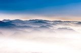 Fototapeta Mglisty góra krajobrazowy widok z niebieskim niebem