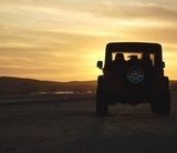 Fototapeta pojazd na pustyni o zachodzie słońca