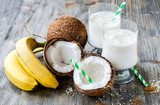 Obraz Kokosowego mleka smoothie napój z bananami na drewnianym tle
