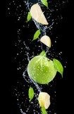 Obraz Zieleni jabłka w wodnym pluśnięciu, odosobnionym na czarnym tle