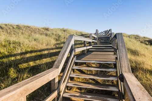Fototapeta Drewniany footpath przez diun przy północnego morza plażą w Niemcy.