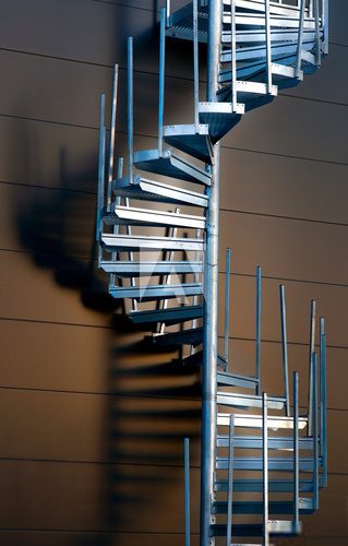 Fototapeta Metalu ślimakowatego schody kastingu cień na ścianie w wieczór świetle