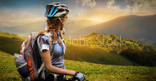 Fototapeta Młoda kobieta z rowerową pozycją w górach