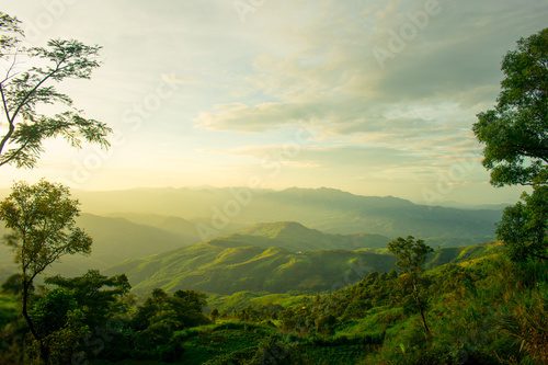 Fototapeta Podłużne góry, zachodzące słońce i las na Doi Tung