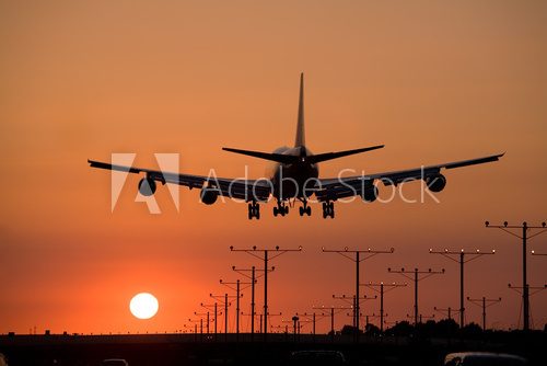Fototapeta Samolot na tle zachodzącego słońca