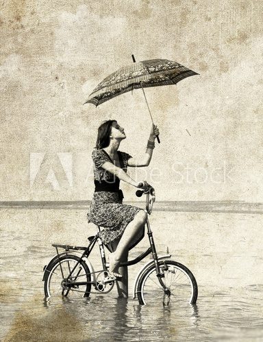 Obraz Dziewczyna z parasolem na rowerze. Zdjęcie w starym stylu obrazu.