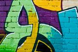 Fototapeta Graffity: Kolorowy szczegół na teksturowanej ścianie z cegły