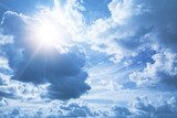 Fototapeta Jaskrawy niebieskiego nieba tło z białymi chmurami i olśniewającym słońcem