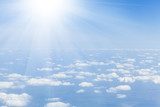 Fototapeta Niebieskie niebo z chmurami i słońcem