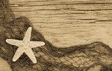 Fototapeta Rozgwiazda i fishnet na wietrzejącym drewnie w sepiowym