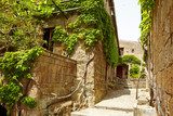 Fototapeta Stara mała kamienna średniowieczna ulica w dziejowym miasteczku, Włochy
