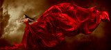 Obraz Kobieta macha piękną suknię z latającą tkaniną w czerwieni