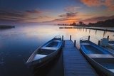 Obraz Pokojowy wschód słońca z dramatycznym niebem, łodziami i jetty